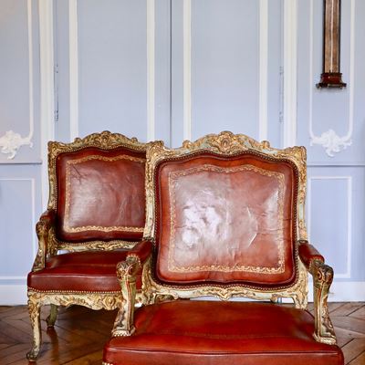 Impressionnante paire de fauteuils à la reine laqués et dorés richement sculptés