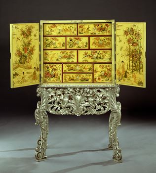 A CHARLES II CREAM JAPANNED CABINET ON SILVERED STAND 
